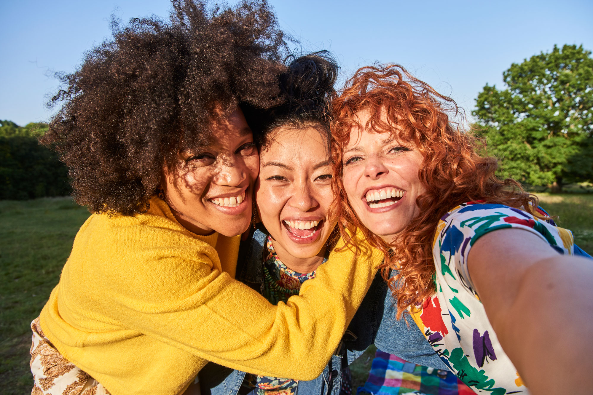Tre glada kvinnor som ler
